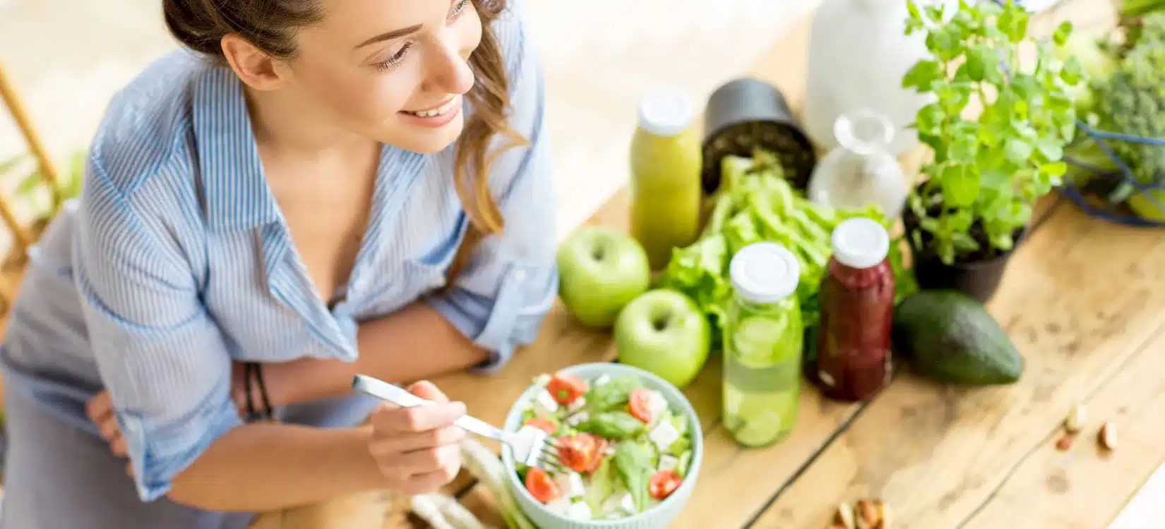 A patient with POTS eating healthy, preparing a nutritious meal with fresh green vegetables, herbs, and a green smoothie.